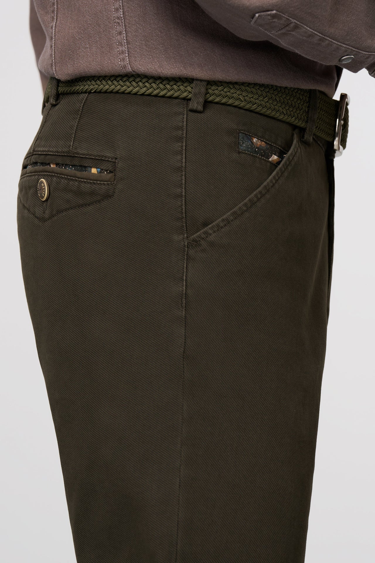 Dark green pants with a belt on a light gray background